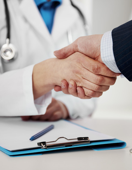 Doctor and person in suit shaking hands